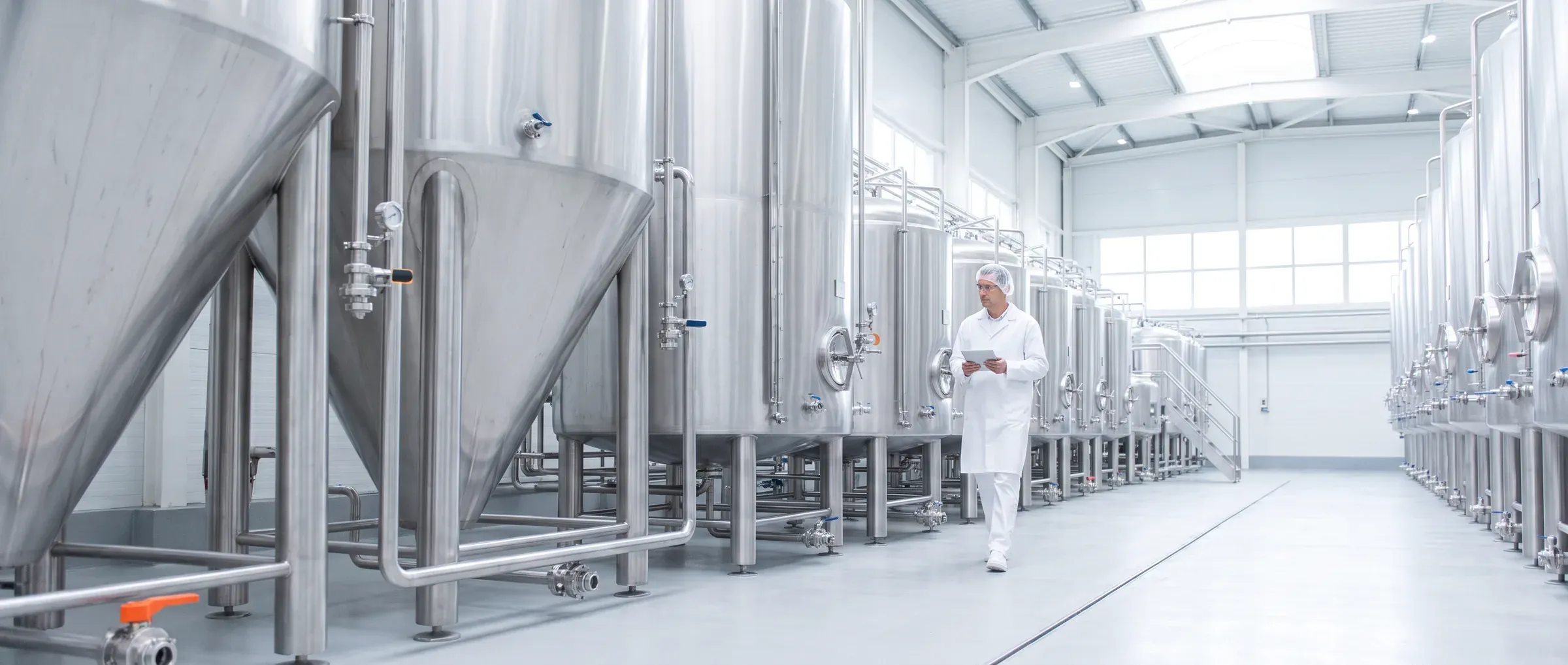 Sala de processo com tanques e tubagens em inox